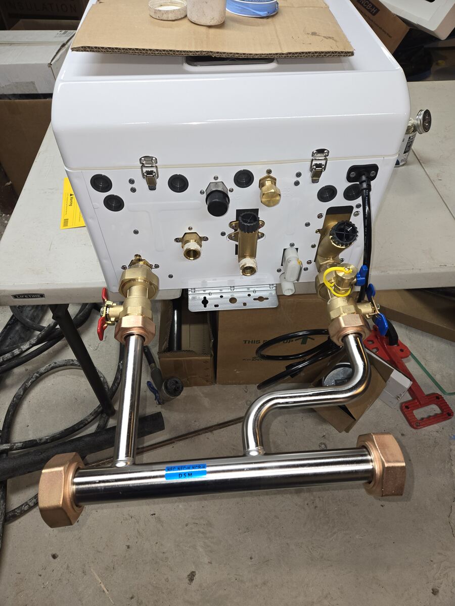 Combi unit on a work table with a stainless steel manifold attached to its connections